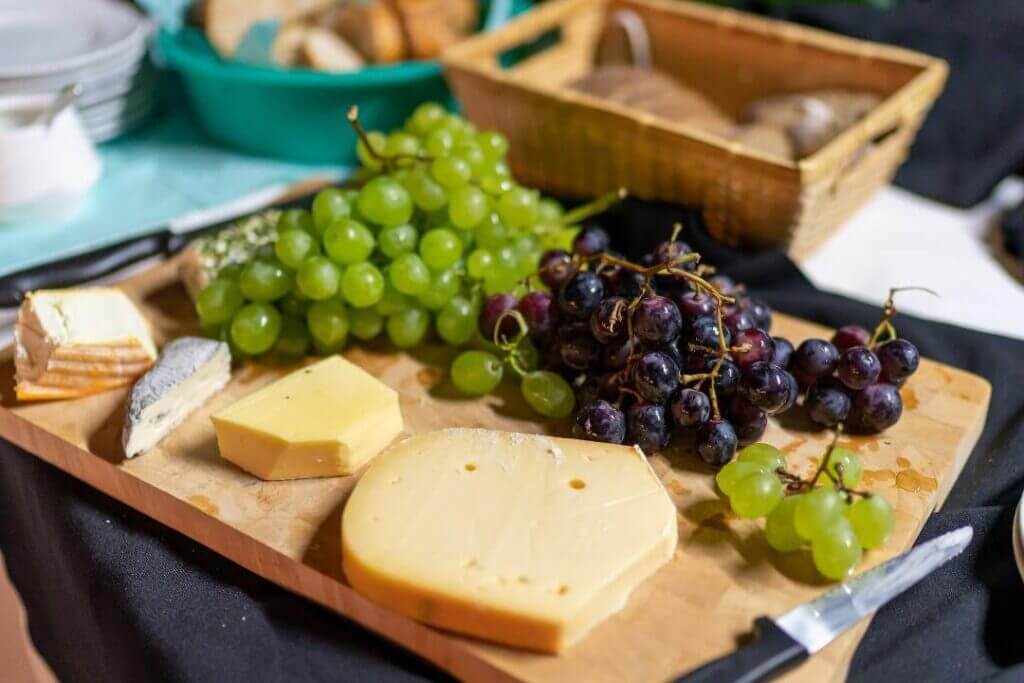 Plateau de fromages sur planche en bois avec raisin