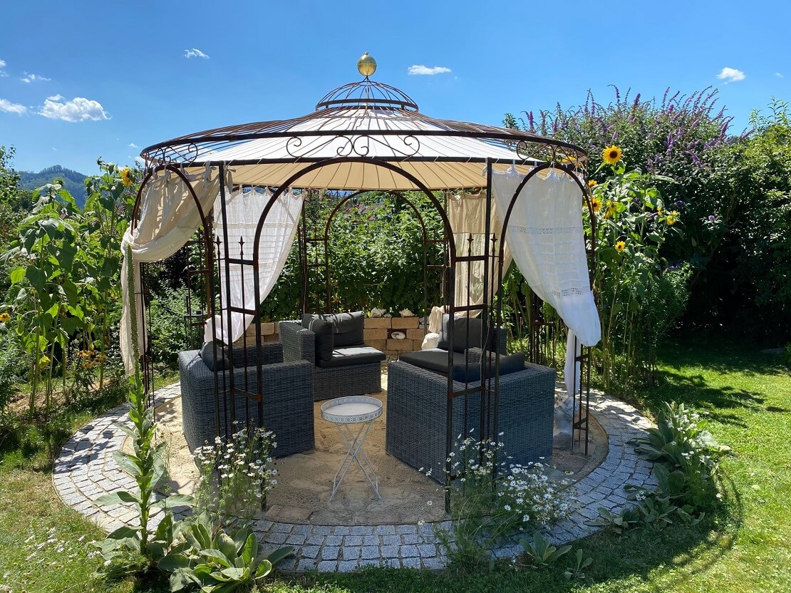 Tonnelle ELEO Firenze intégrée dans un jardin avec une végétalisation à base de tournesols.